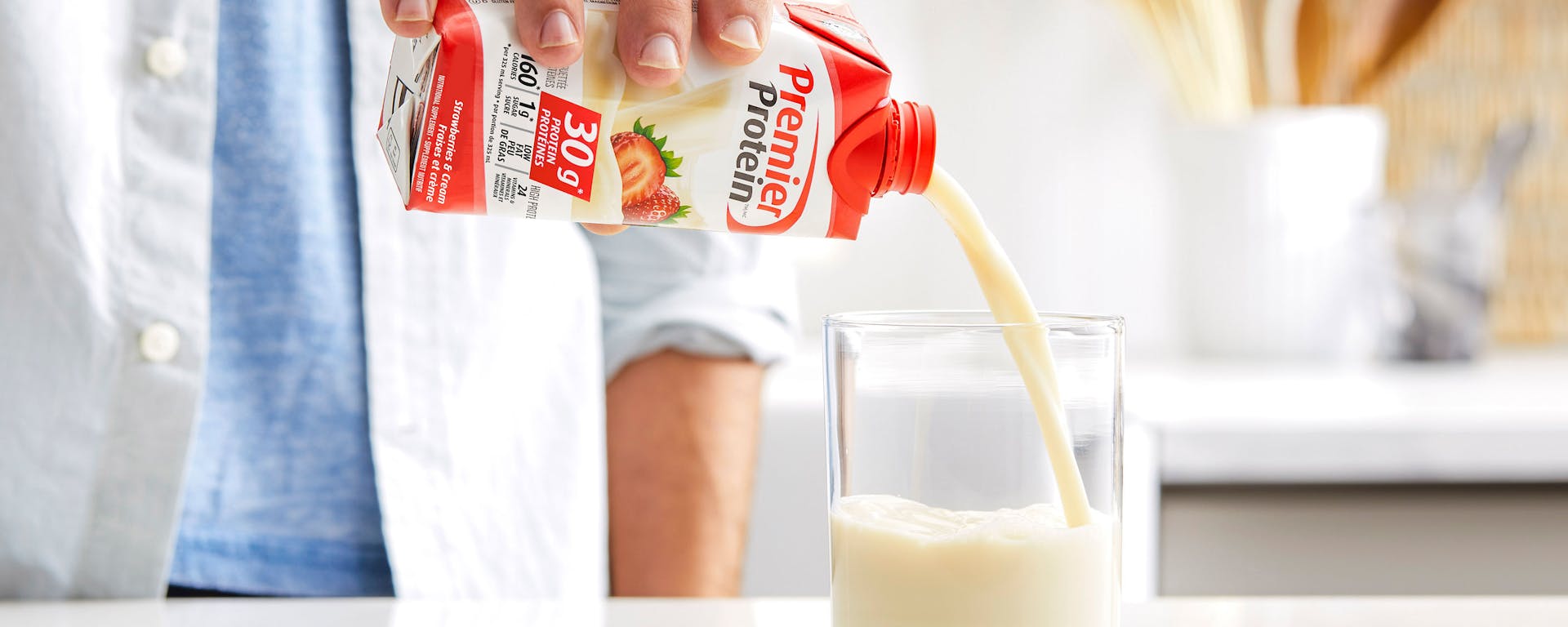 A Premier Protein shake being poured into a glass.