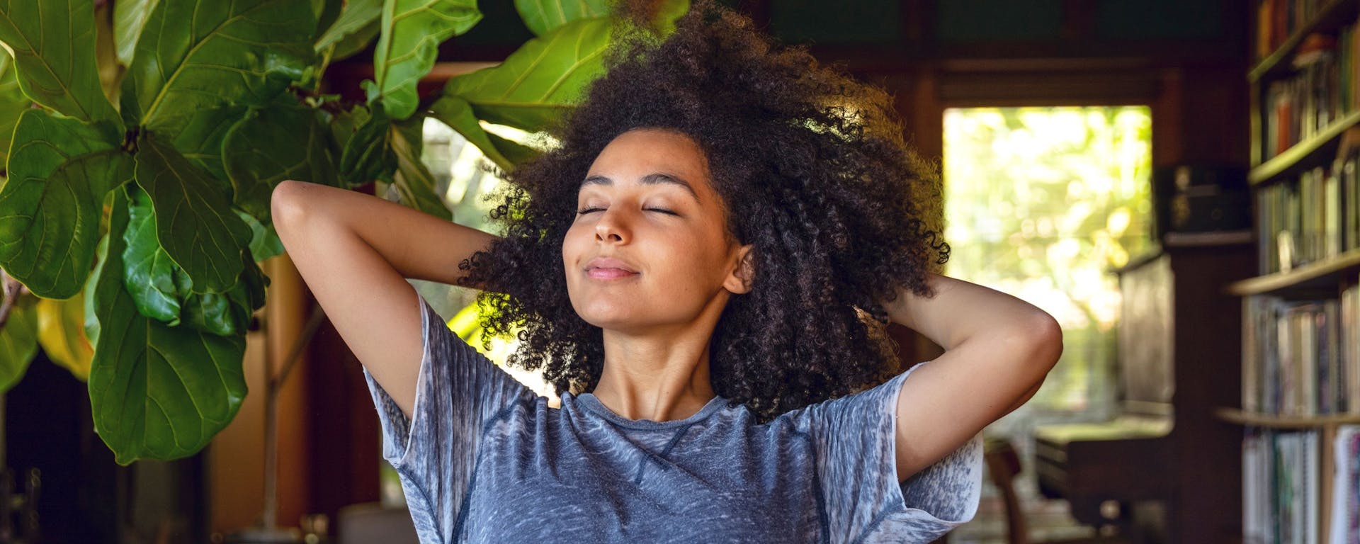 A women relaxing with her hands behind her head.